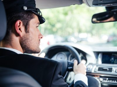 Photo of a professional chauffeur driving high-profile client to a meeting