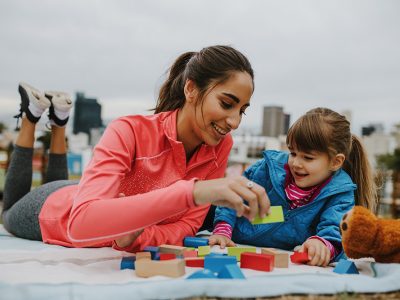 Girl and nanny playing wooden blocks