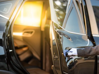 Closeup of Chauffeur opening car door with glove.